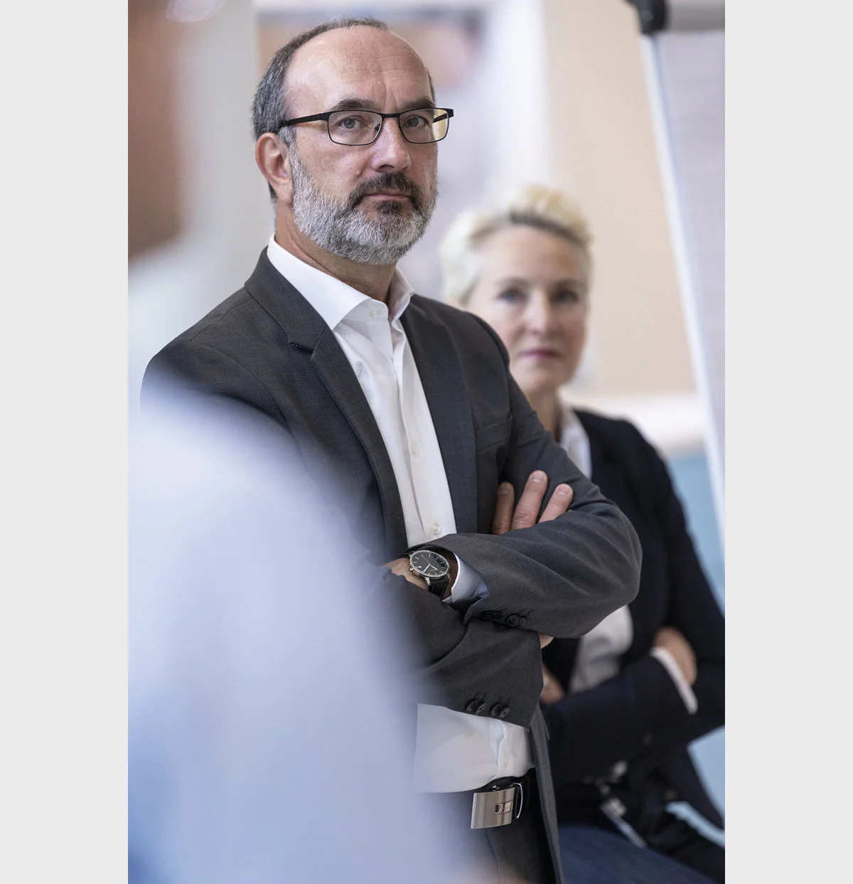 Mann mit Brille und verschränkten Armen in einem Gespräch bei Eppendorf.