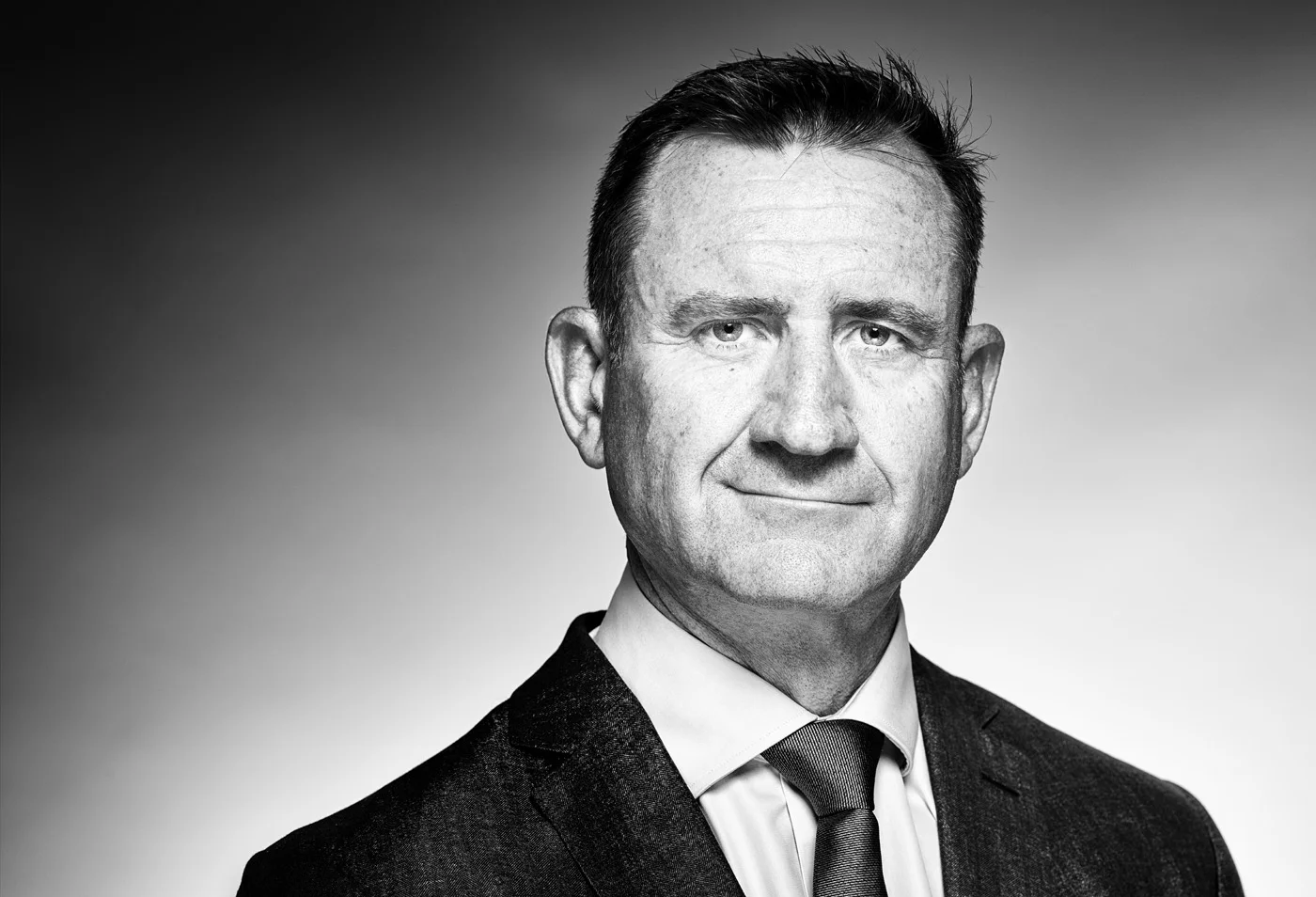 Schwarzweiß-Businessporträt von Andrew Rennie, zum Aufnahmezeitpunkt CEO Europe von Domino’s Pizza Enterprises.